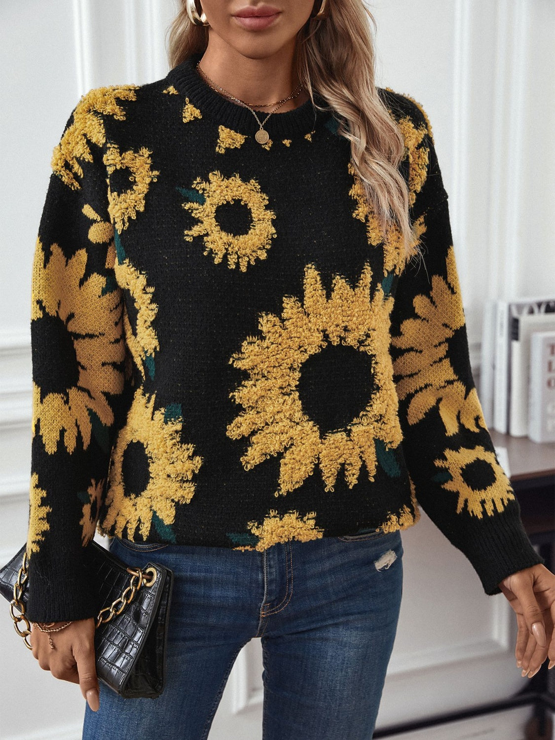 Bohemian-inspired black sweater with textured sunflower designs.
