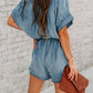 Chic denim romper with notched neckline and adjustable tie waist for a perfect fit. Versatile, comfortable, and perfect for summer days.