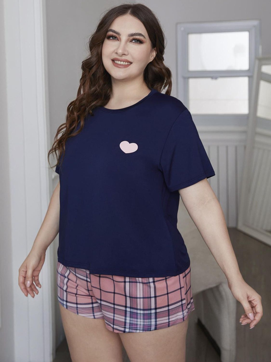 Cozy up in style with our Plus Size Loungewear Set, featuring a cute heart top and comfy plaid shorts. Perfect for relaxing days at home!