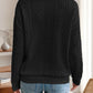 Back view of the black quarter-zip knit sweater, featuring its classic cable knit pattern and relaxed fit.

