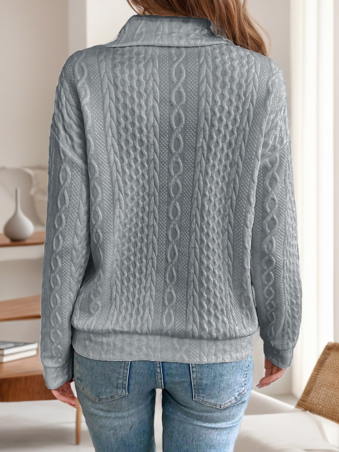 Back view of a gray quarter-zip knit sweater, featuring a relaxed fit and soft knit fabric.

