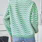 Back view of the green wavy striped sweater, showing the relaxed fit and playful design.

