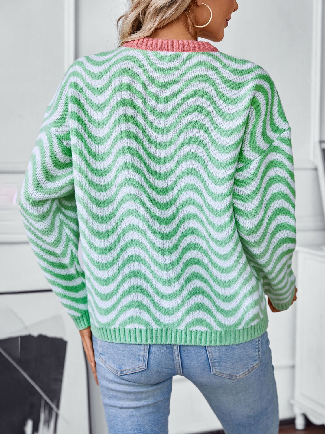 Back view of the green wavy striped sweater, showing the relaxed fit and playful design.

