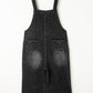 Back view of black washed distressed overalls with two back pockets.
