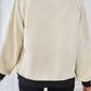 Back view of the beige and black pullover, showcasing the geometric pattern and cozy fit.

