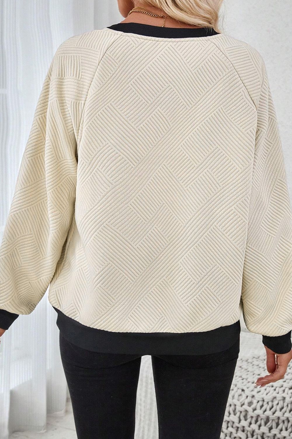 Back view of the beige and black pullover, showcasing the geometric pattern and cozy fit.

