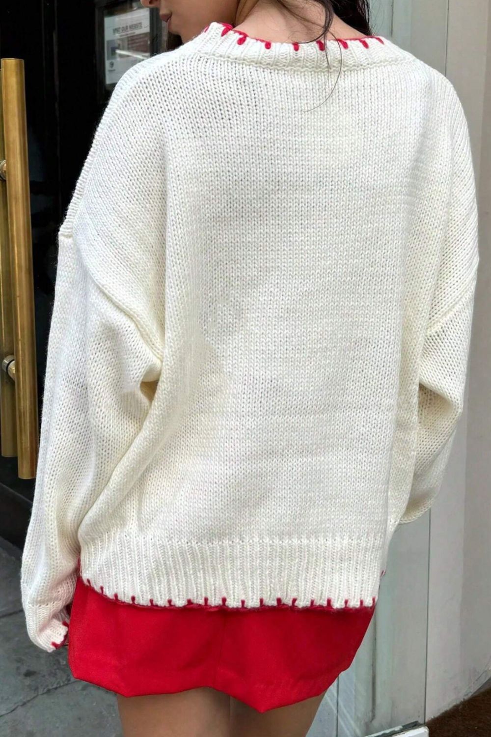 Back view of a white knit sweater featuring an oversized bow, perfect for casual winter days.

