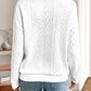 Back view of a white quarter-zip knit sweater, showing its relaxed fit and cable knit detailing.

