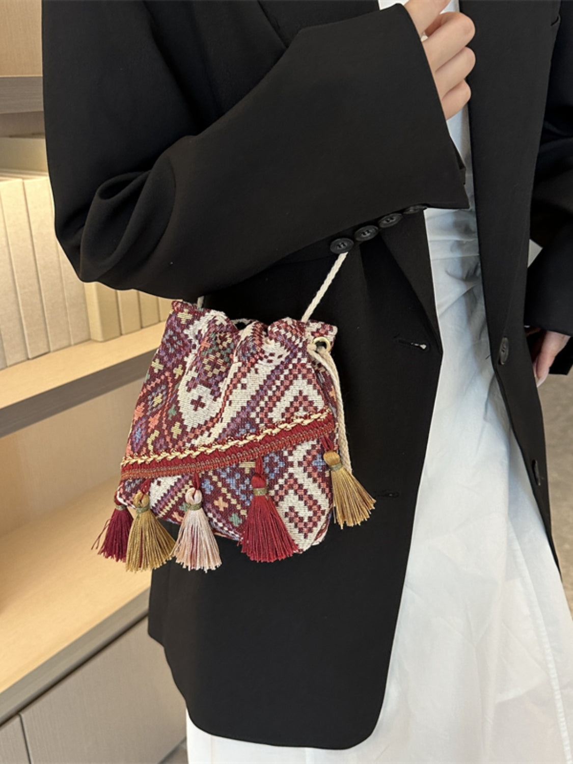 Wine geometric print pouch with drawstring closure and stylish tassel details.