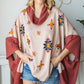 Cozy oversized poncho with a cowl neck and vibrant Aztec pattern in beige and rust.