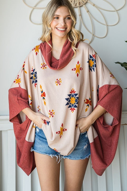 Cozy oversized poncho with a cowl neck and vibrant Aztec pattern in beige and rust.