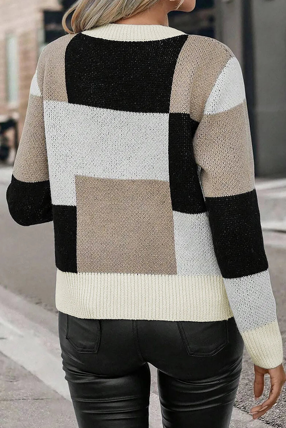 Close-up of a color block sweater with bold, neutral-toned blocks.
