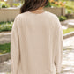 Beige high-waist shorts paired with an oversized drop-sleeve top.
