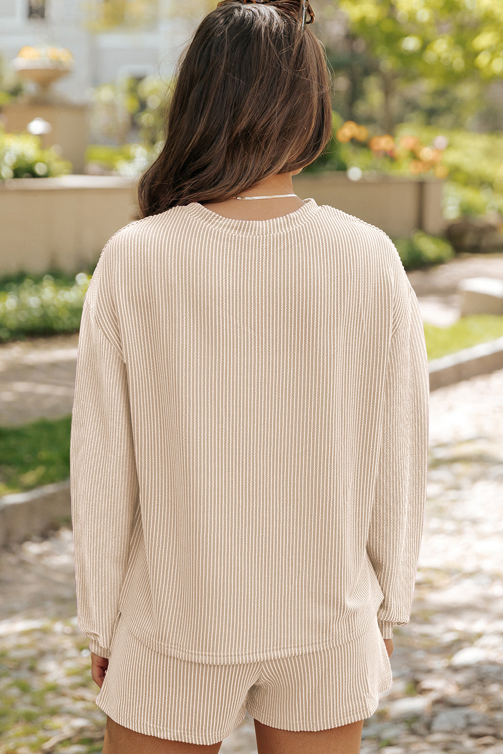 Beige high-waist shorts paired with an oversized drop-sleeve top.
