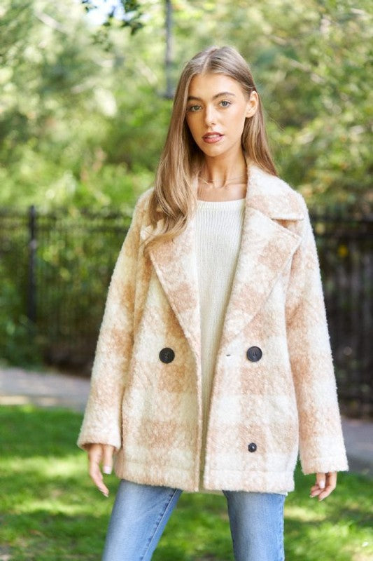 Beige fuzzy boucle coat for women, styled with a casual outfit for a cozy look.
