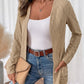 Open front beige cable knit cardigan, versatile enough to pair with a variety of outfits for different occasions.