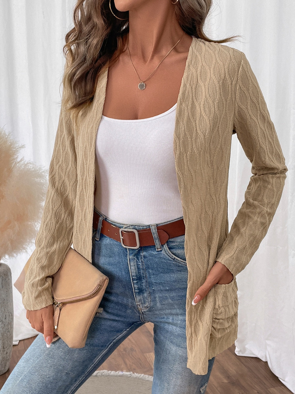 Open front beige cable knit cardigan, versatile enough to pair with a variety of outfits for different occasions.