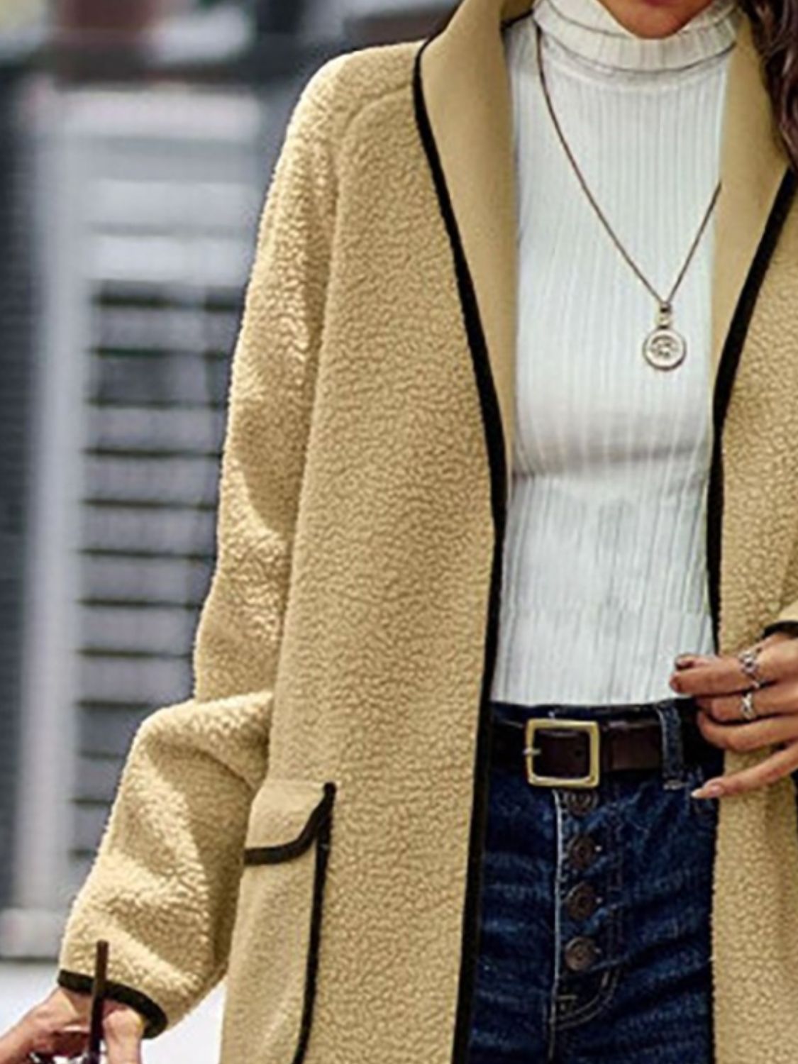 Beige long sherpa coat with contrast detailing for a contemporary look.
