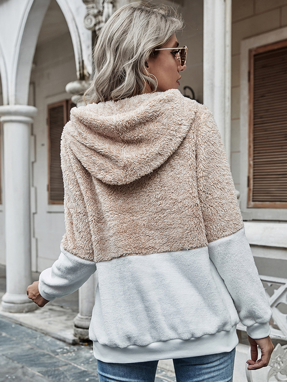 Back view of a cozy beige and white color-block sherpa pullover hoodie.
