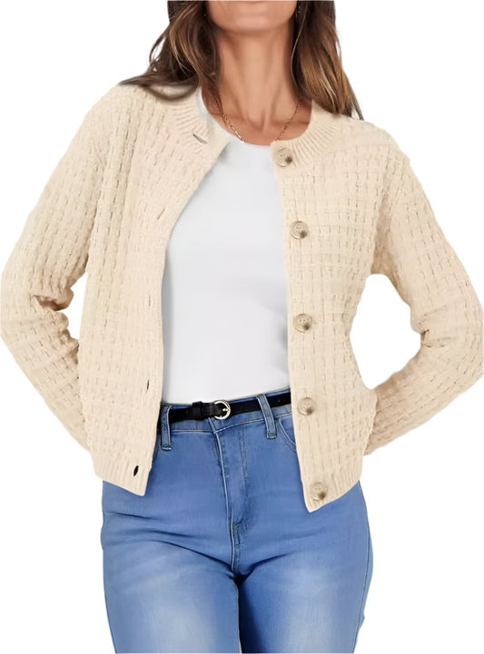 Woman wearing a beige textured knit button-up cardigan with blue jeans.
