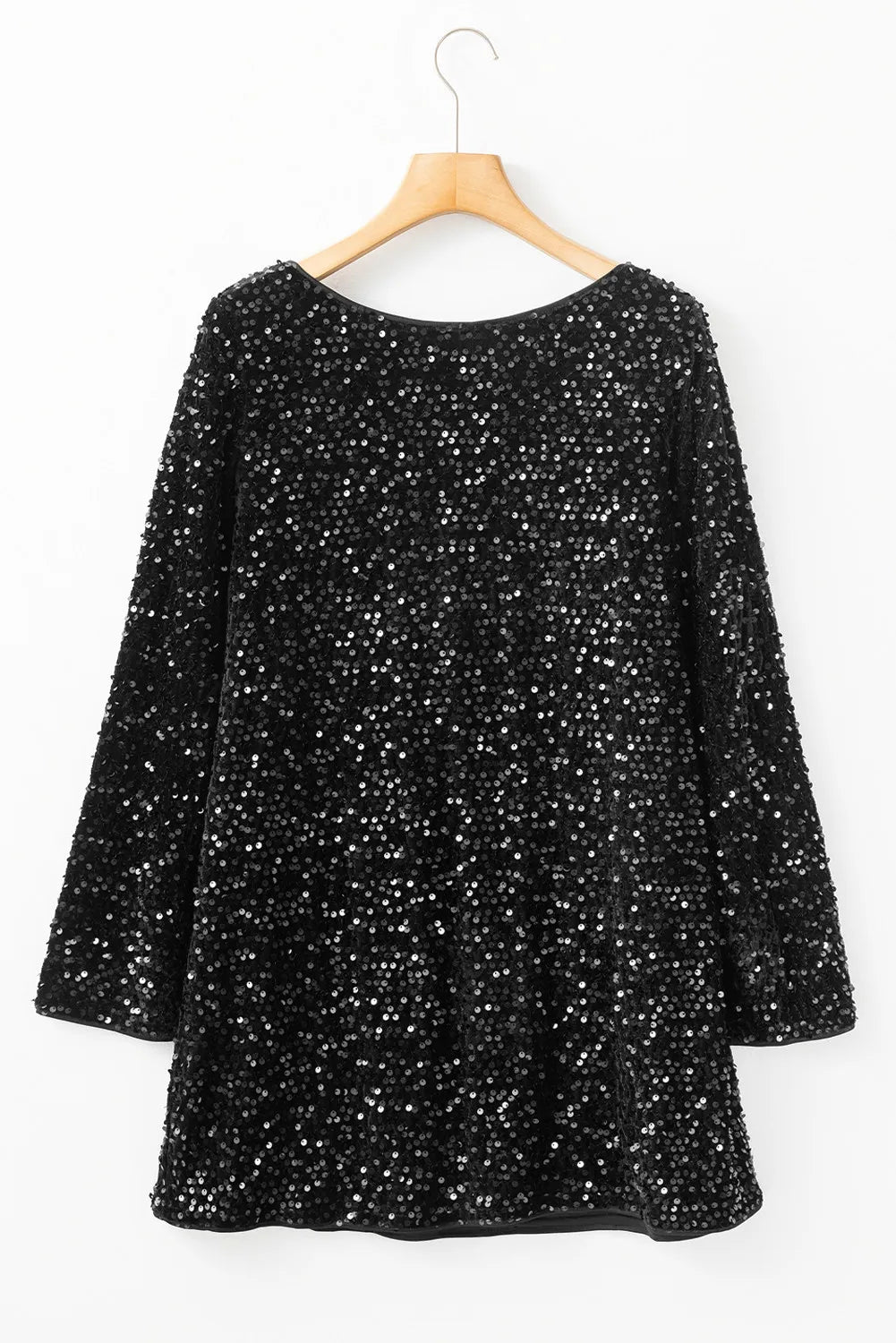 Woman in black sequin dress with bell sleeves and A-line fit.
