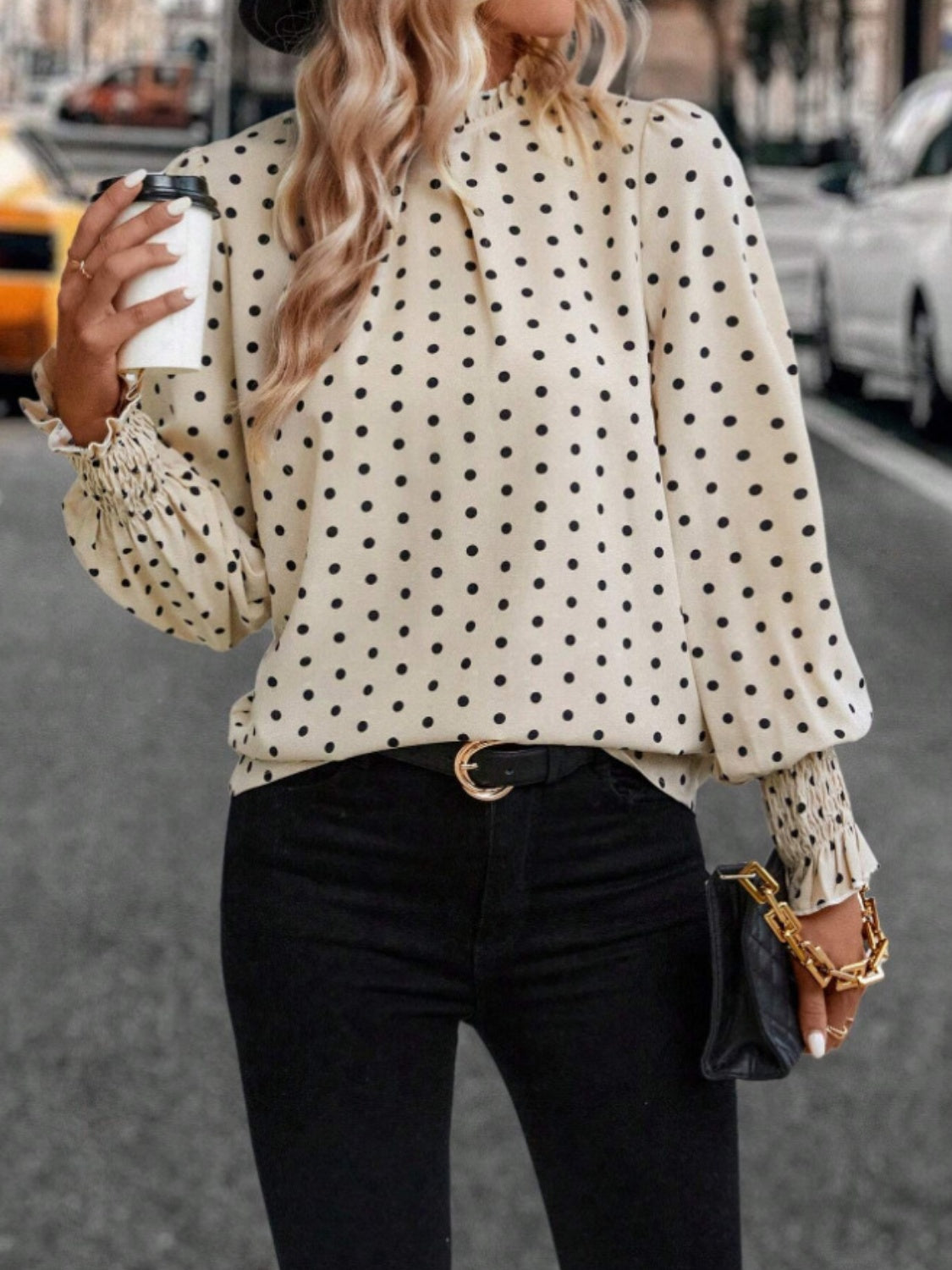 Classic polka dot blouse with ruffled cuffs, featuring a delicate neckline, perfect for a chic look.
