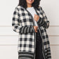 Woman wearing black and ivory plaid cardigan, front view.