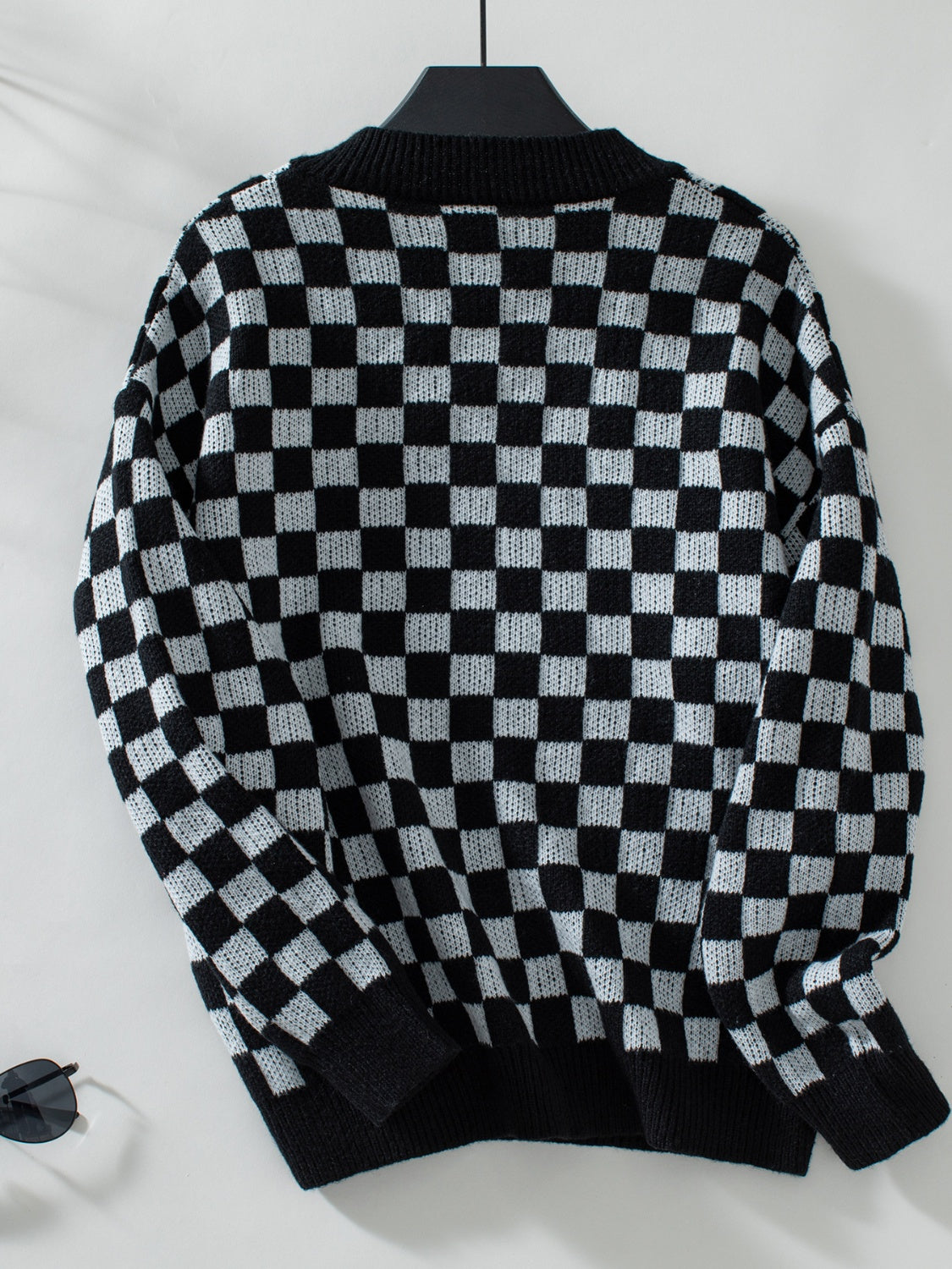 Soft black and white checkerboard sweater with a relaxed fit.
