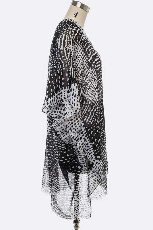 Side view of a chic kimono cardigan featuring a black-and-white dot pattern.
