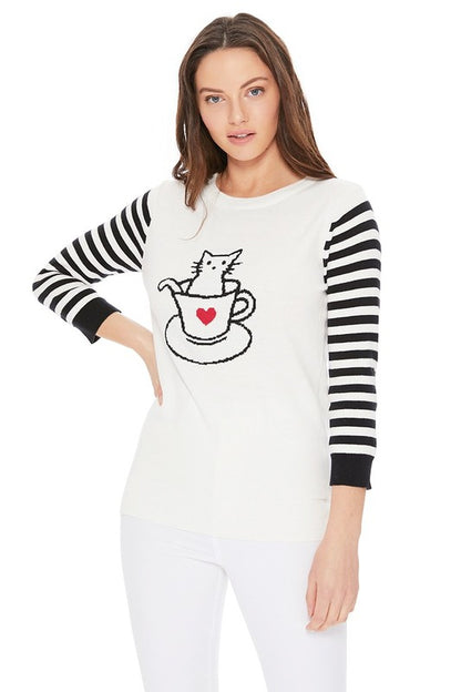 Playful cat in cup sweater with black and white striped sleeves for a trendy look.
