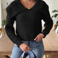 Warm black cable-knit sweater paired with light-wash denim.
