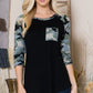 Black top with camo print sleeves and pocket
