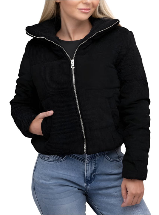 Woman wearing a black corduroy zip-up jacket with a high collar and practical pocket, paired with jeans.
