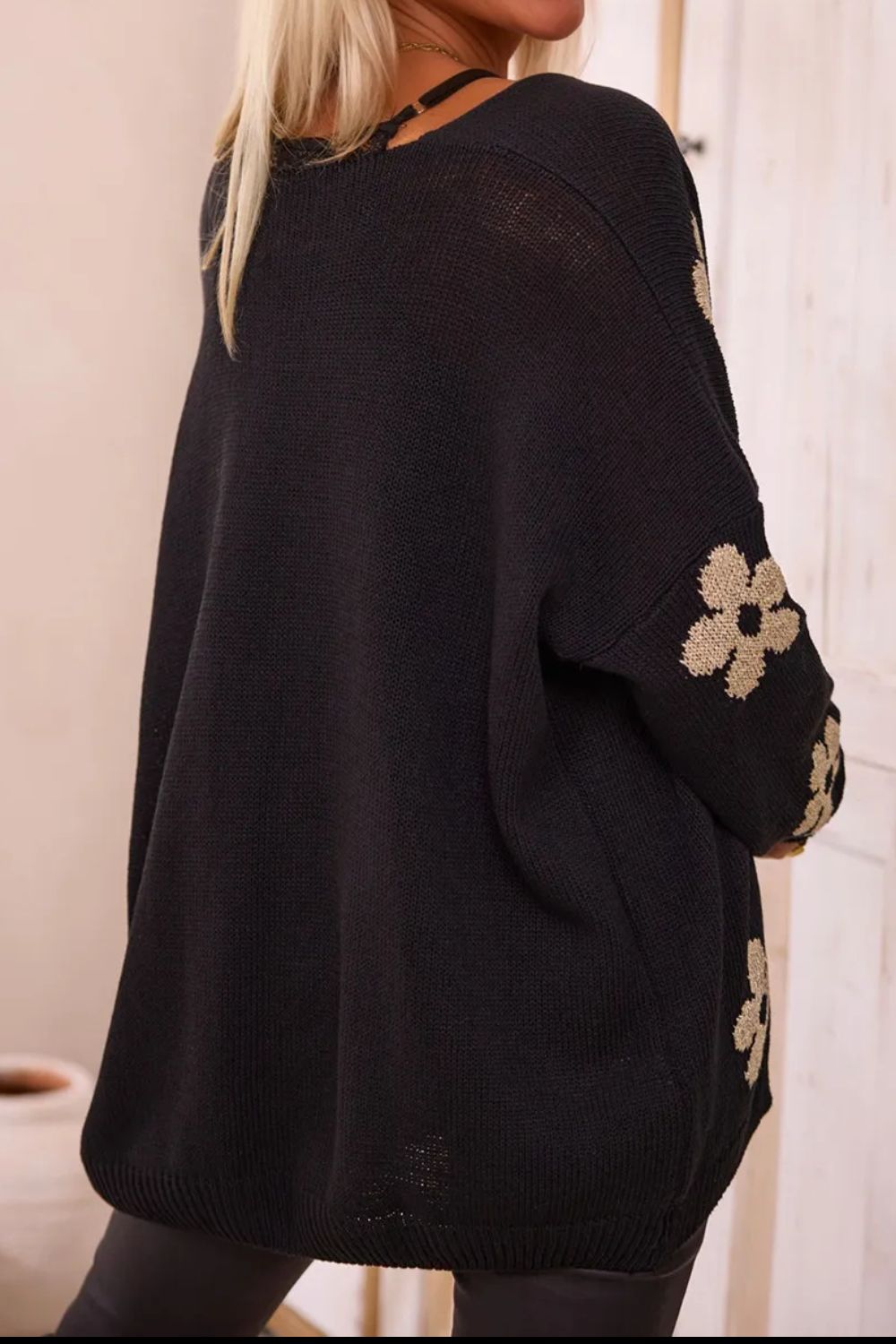 Back view of black floral cardigan with relaxed fit