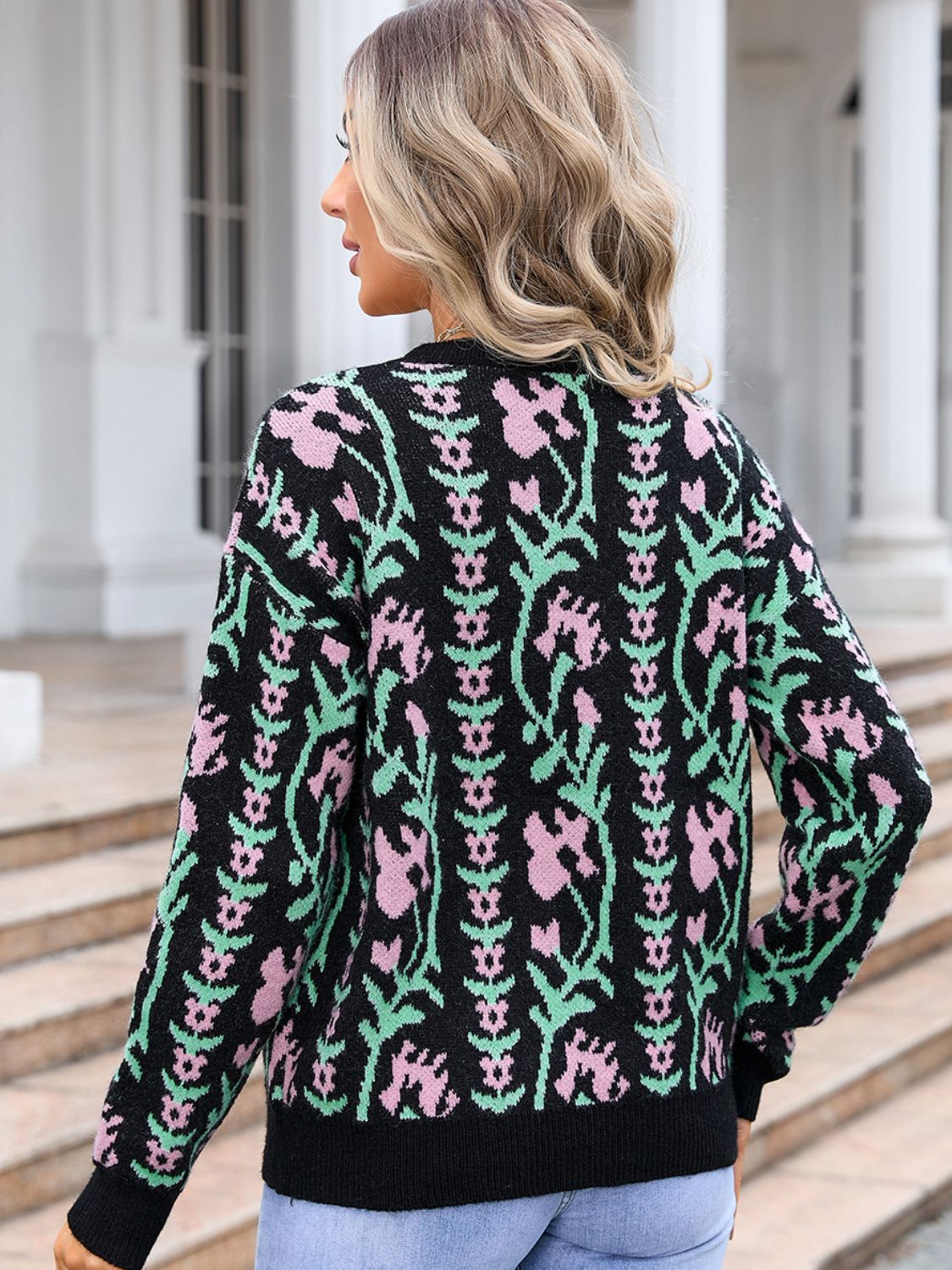 Woman in black floral knit sweater with relaxed fit and round neck