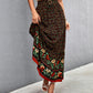 Front view of a black high-waist floral long skirt with a vibrant floral print.
