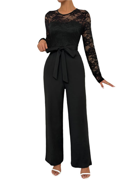 Woman wearing an elegant black lace jumpsuit with a waist tie.
