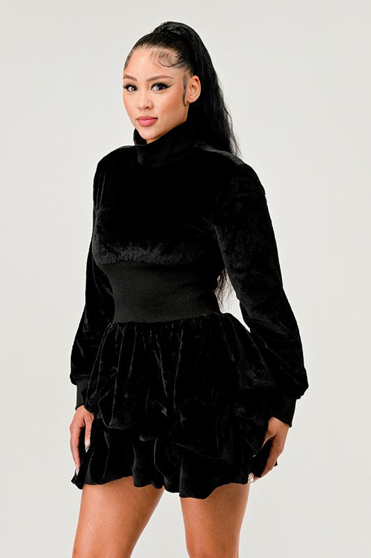 Black long sleeve dress featuring cascading ruffles and a mock neck.
