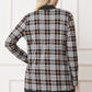 Detailed view of plaid pattern on cardigan with black trim