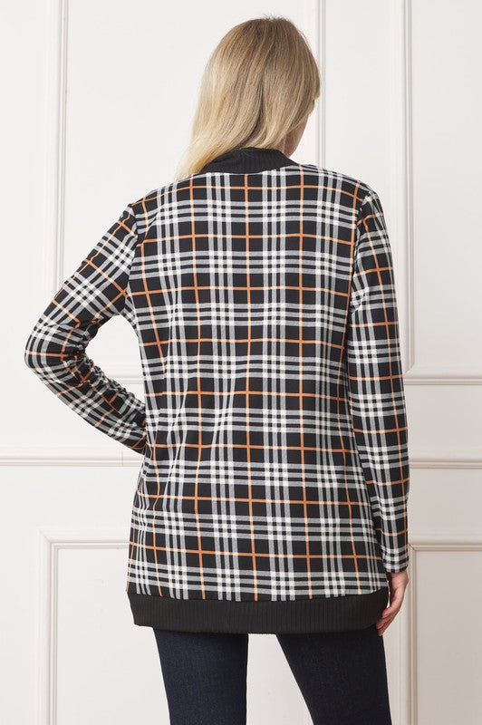 Detailed view of plaid pattern on cardigan with black trim