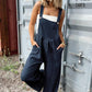 Wide-strap plaid jumpsuit with a front pocket for functional style.
