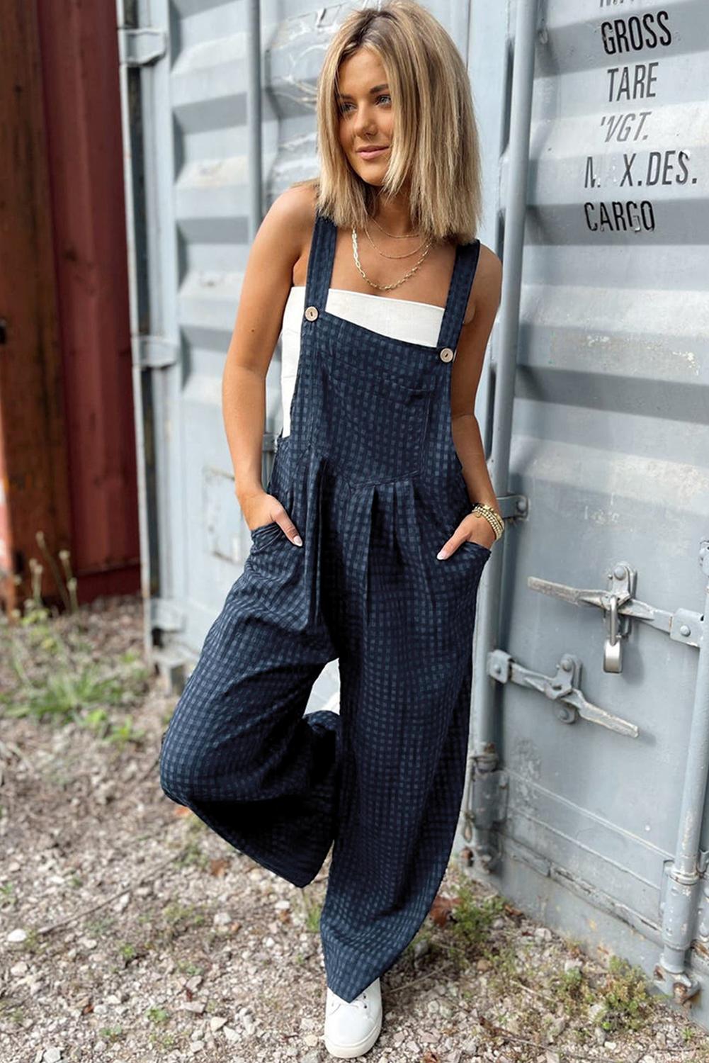 Wide-strap plaid jumpsuit with a front pocket for functional style.
