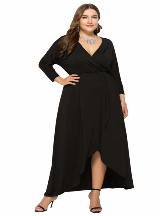 Full-length image of a black plus-size dress with an elegant draped hemline.
