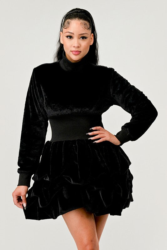 Front view of a black ruffle mock neck dress with long sleeves and a playful skirt.
