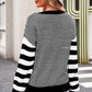 Lightweight black round neck sweater, perfect for layering in cooler months.
