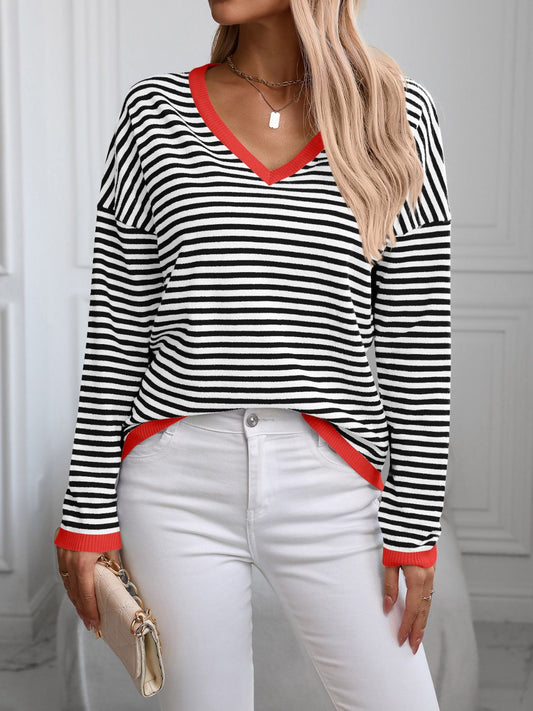 Black and white striped knit top with red contrast trim, styled with a clutch.
