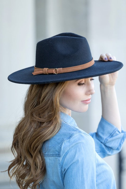 Closeup of black Panama hat featuring a tan tassel belt for added detail.
