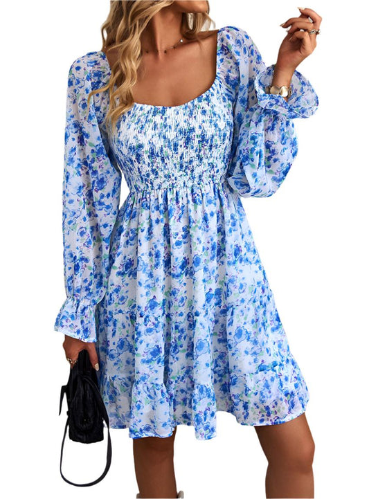 Blue bohemian floral dress with a square neckline, flowy long sleeves, and tiered hemline.
