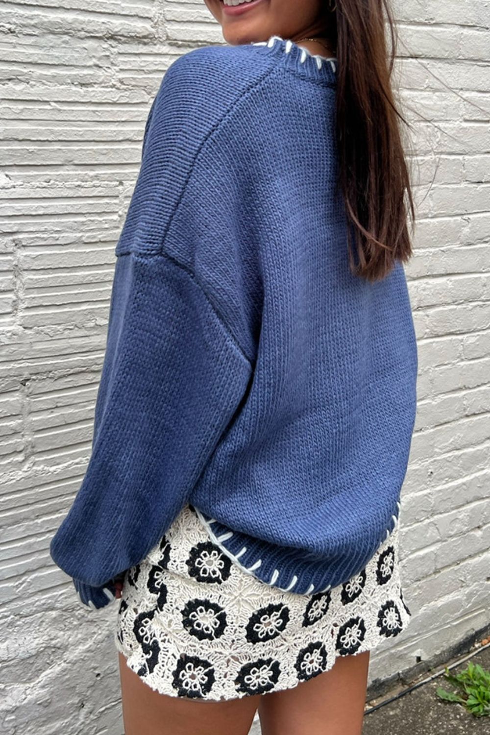 Blue knit sweater with an oversized bow detail, perfect for layering during cold winter months.

