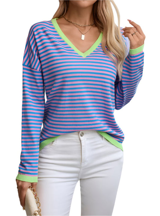 Woman wearing a blue and pink striped V-neck knit top with green contrast trim.
